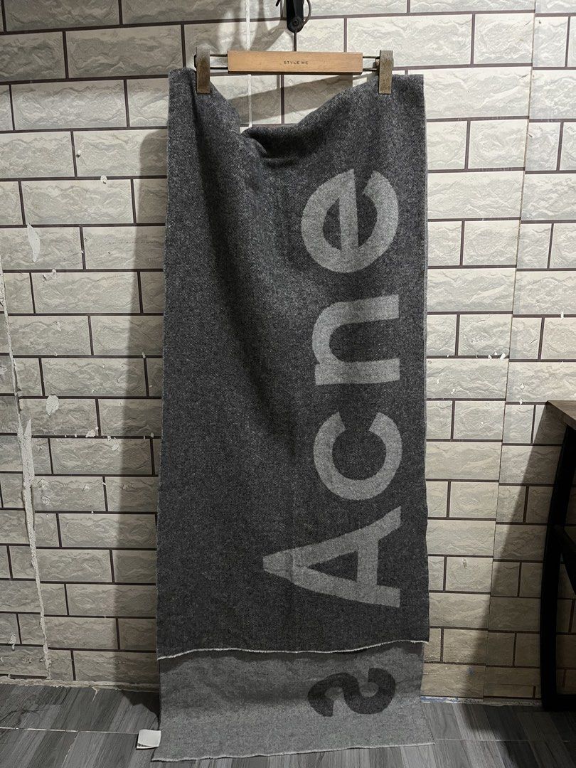 Acne Studios Grey Logo Scarf (Category: Scarves) located in Manila. Submitted by kuya_erick62 (Listing ID 1470760564, Image 1). Description: - Brand: Acne Studios - Color: Dark grey with contrasting light grey text graphic - Material: 80% wool, 20% nylon blend - Origin: Made in Italy - Dimensions: 220 x 50 cm - Condition: Brand new with tag attached - Care: Delicate dry clean only.