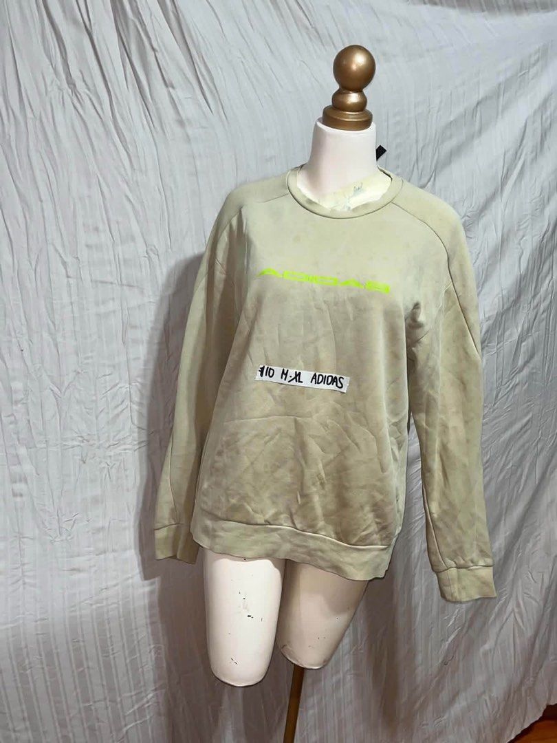 Adidas Beige Sweatshirt Crewneck (Category: Coats, Jackets and Outerwear) located in General Trias. Submitted by crissy9053136 (Listing ID 1470761359, Image 1). Description: - Brand: Adidas - Style: Crewneck sweatshirt - Color: Beige with neon yellow chest logo - Fit: Relaxed fit with long sleeves, ribbed cuffs and hem - Material: Super comfortable cotton - Size: M-XL (per tag) - Condition: Clean and ready to wear.