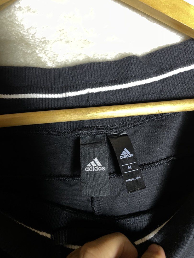 Adidas Black Joggers Sweatpants (Category: Joggers) located in Molave. Submitted by charlesthrifter (Listing ID 1470853849, Image 2). Description: - Brand: adidas - Color: Black - Size: Medium (M) - Material: 67% cotton, 33% recycled polyester - Waistband: Striped elastic with adjustable drawstring - Pockets: Secure zippered pockets on both sides - Branding: Iconic white adidas logo on the left leg - Origin: Made in China - Condition: Brand new /