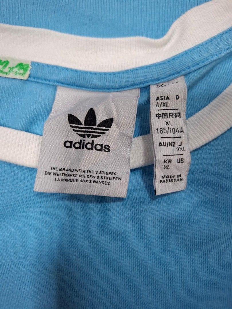 Adidas Blue Ringer T-Shirt White Stripes (Category: Shirts) located in Manila. Submitted by jazil.ladyliz (Listing ID 1470762233, Image 3). Description: - Brand: Adidas - Style: Light blue ringer t-shirt with white contrast collar, sleeve cuffs, and 3-stripes - Details: Classic embroidered trefoil logo on the chest - Size: XL - Material: Soft cotton - Condition: Good, with a small faint stain on the front chest (circled in yellow in the last phot