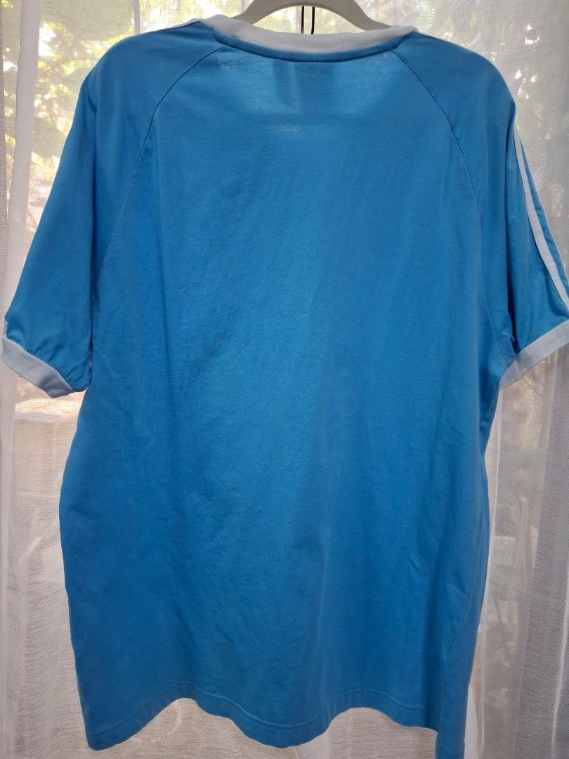 Adidas Blue Ringer T-Shirt White Stripes (Category: Shirts) located in Manila. Submitted by jazil.ladyliz (Listing ID 1470762233, Image 2). Description: - Brand: Adidas - Style: Light blue ringer t-shirt with white contrast collar, sleeve cuffs, and 3-stripes - Details: Classic embroidered trefoil logo on the chest - Size: XL - Material: Soft cotton - Condition: Good, with a small faint stain on the front chest (circled in yellow in the last phot