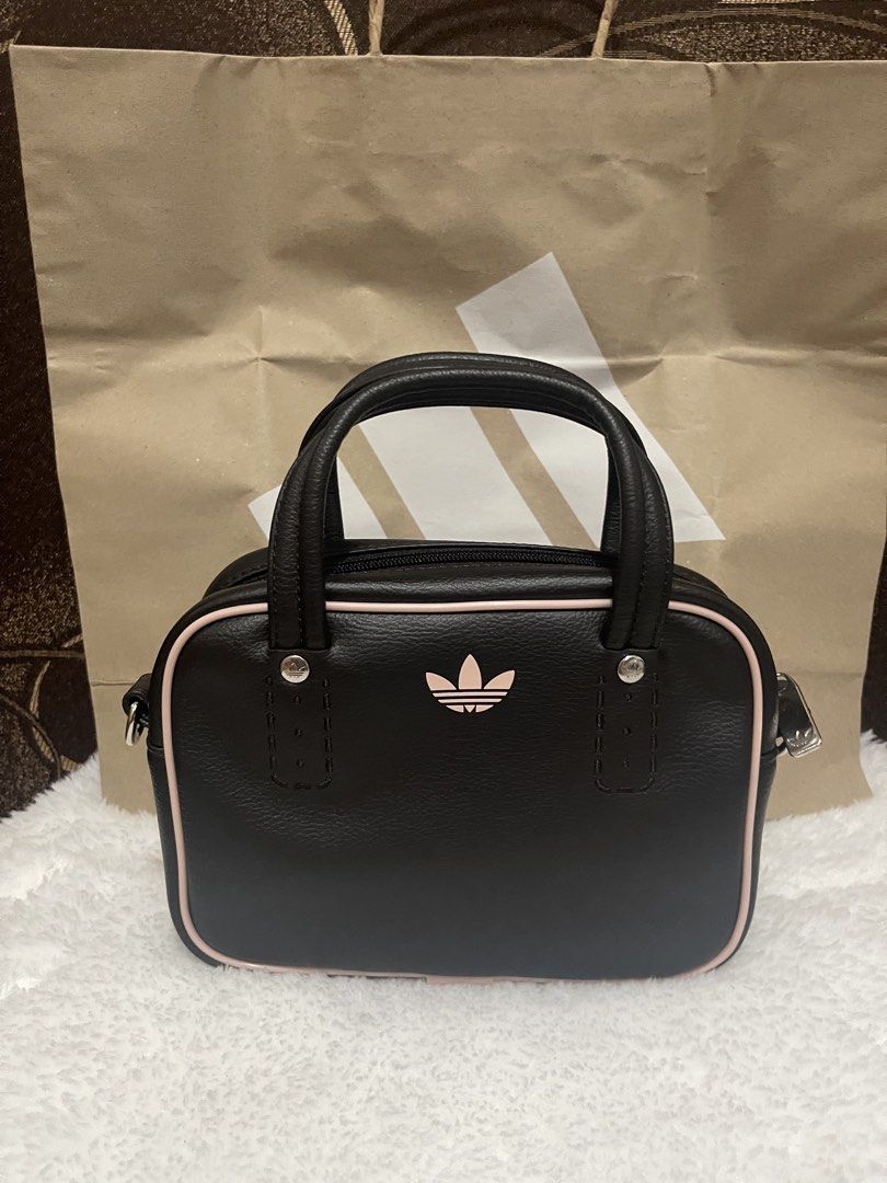 Adidas Brown and Pink Mini Handbag (Category: Luxury Bags & Wallets) located in Manila. Submitted by sunflowermama904 (Listing ID 1470769427, Image 1). Description: - Brand: Adidas - Style: Mini handbag / everyday bag - Material/Finish: Brown leather-look - Details: Light pink piping, matching pink trefoil logo, and silver hardware - Closure: Top zip closure - Handles: Double top handles - Condition: Brand new / Excellent (ready to ship).