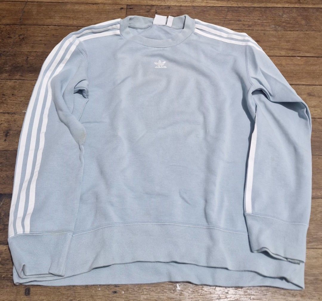 Adidas Light Blue Three Stripe Crewneck Sweatshirt (Category: Coats, Jackets and Outerwear) located in Manila. Submitted by martinezjonill (Listing ID 1470885823, Image 1). Description: - Brand: Adidas - Style: Crewneck sweatshirt - Color: Light blue with classic white three stripes - Details: Small embroidered trefoil logo on chest, ribbed cuffs, collar, and hem - Condition: Great casual piece, but has a slight yellowish stain on the right sleev