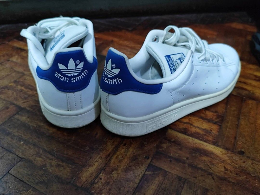 Adidas Stan Smith White Blue Sneakers (Category: Sneakers) located in Bacoor. Submitted by stargazer1084 (Listing ID 1470835653, Image 2). Description: - Color/Design: White leather with stylish blue heel tabs - Branding: Classic Stan Smith logo on tongue and back - Details: Low-top cut, white laces, and signature perforated three stripes - Condition: Brand new/unused, with slight yellowing on the soles due to storage/age - Perfect for everyday c