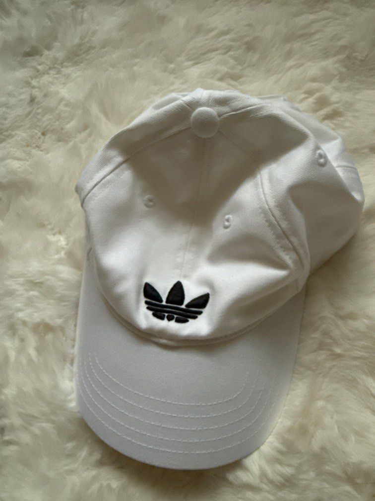 Adidas Trefoil Baseball Cap White (Category: Caps & Hats) located in Manila. Submitted by preshyyyyy_ (Listing ID 1470743787, Image 2). Description: - Brand: Adidas - Color: White with black embroidered trefoil logo - Condition: Brand new with original retail tags attached - Design: Classic six-panel structure with embroidered eyelets for airflow - Closure: Adjustable strapback for a custom fit - Details: Interior branding tape along seams.