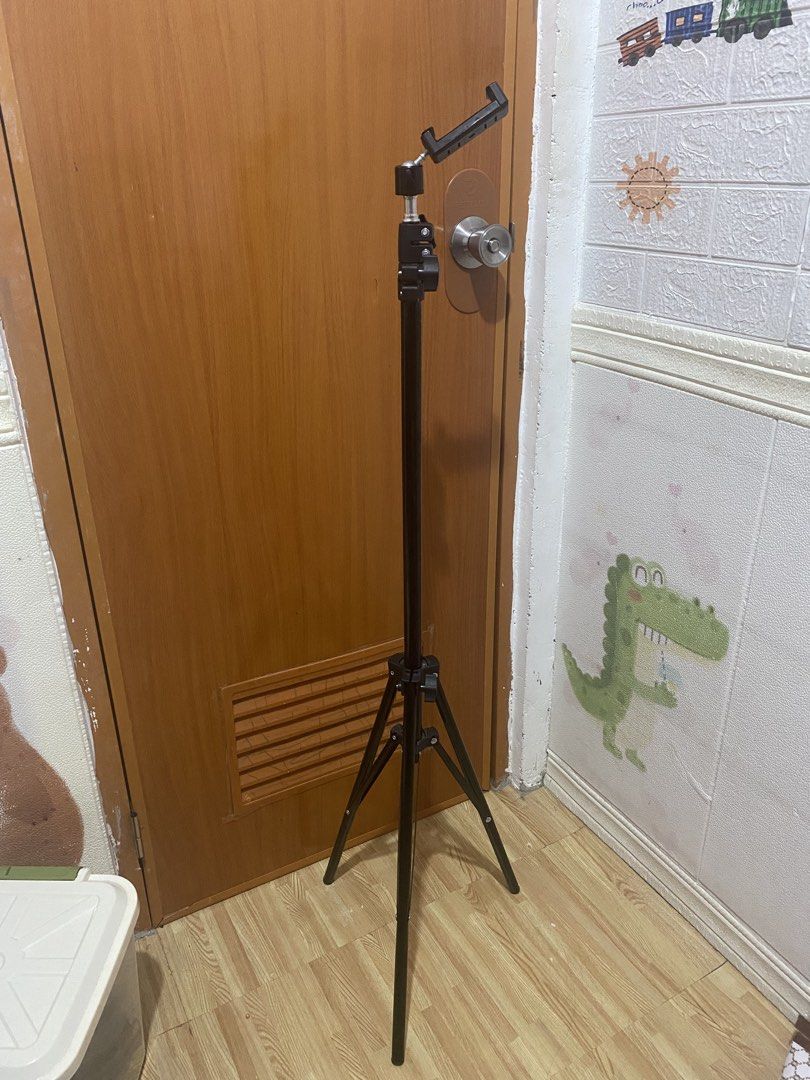 Adjustable black phone tripod stand (Category: Tripods & Monopods) located in Las Pinas. Submitted by stylishchique (Listing ID 1470834052, Image 1). Description: - Adjustable black tripod stand with included phone holder clip - Telescopic metal legs easily adjust to your preferred height - Folds down compactly for easy storage and travel - Stable base with rubber feet to prevent slipping - Ideal for video recording, live streaming, and taking gr