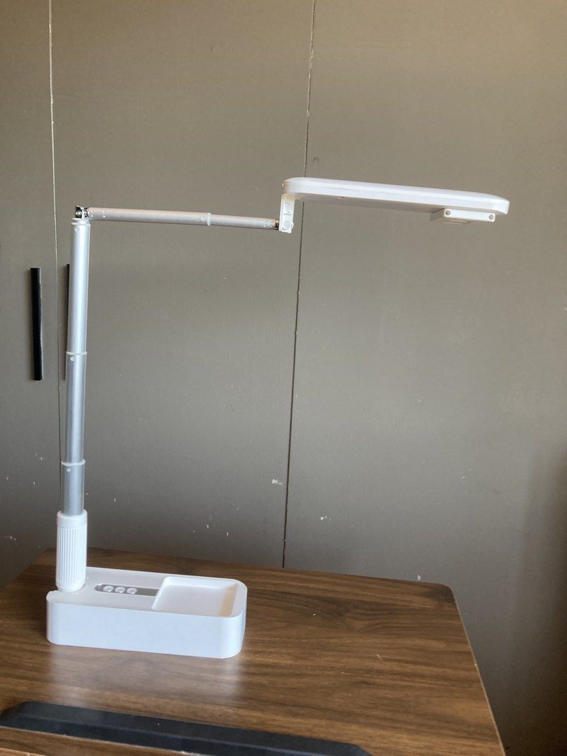 Adjustable Phone Holder Tripod Foldable Portable Stand (Category: Mounts & Holders) located in Iligan City. Submitted by phoebedecluttersorigitems (Listing ID 1470746241, Image 3). Description: - Sleek white and silver LED desk lamp - Adjustable head and telescopic pole for custom lighting - Foldable, compact design for easy storage and portability - Convenient control buttons located on the base - Perfect for studying, working, or home office us