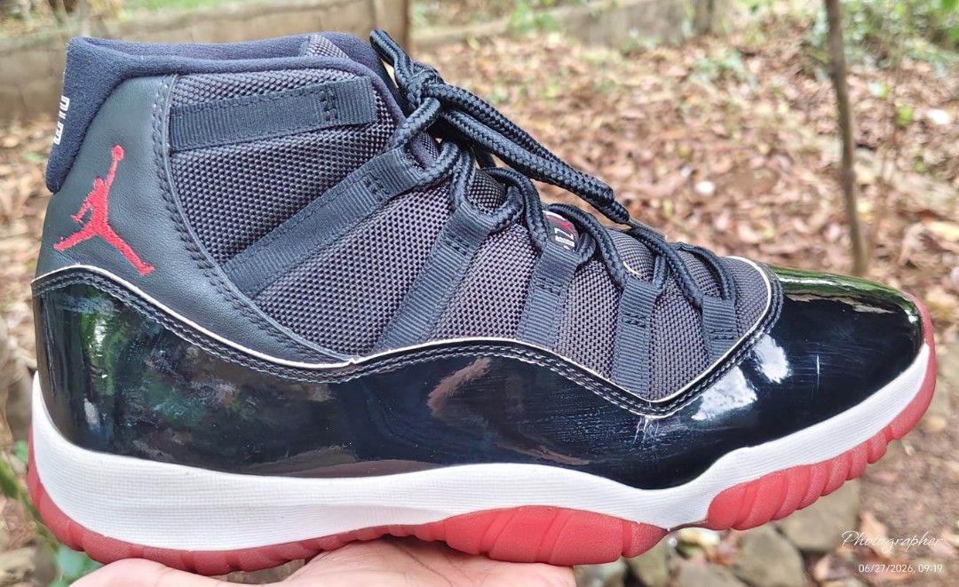 Air Jordan 11 Retro Bred (Category: Sneakers) located in Manila. Submitted by sansmerci27 (Listing ID 1470899017, Image 3). Description: - Model: Air Jordan 11 Retro - Colorway: Iconic Black and Red (Bred) - Details: Glossy patent leather mudguard, black mesh upper, matching rope laces - Soles: White midsole with bright red outsole - Branding: Red embroidered Jumpman logo near the ankle - Condition: Great addition to any sneaker rotation - Meetup