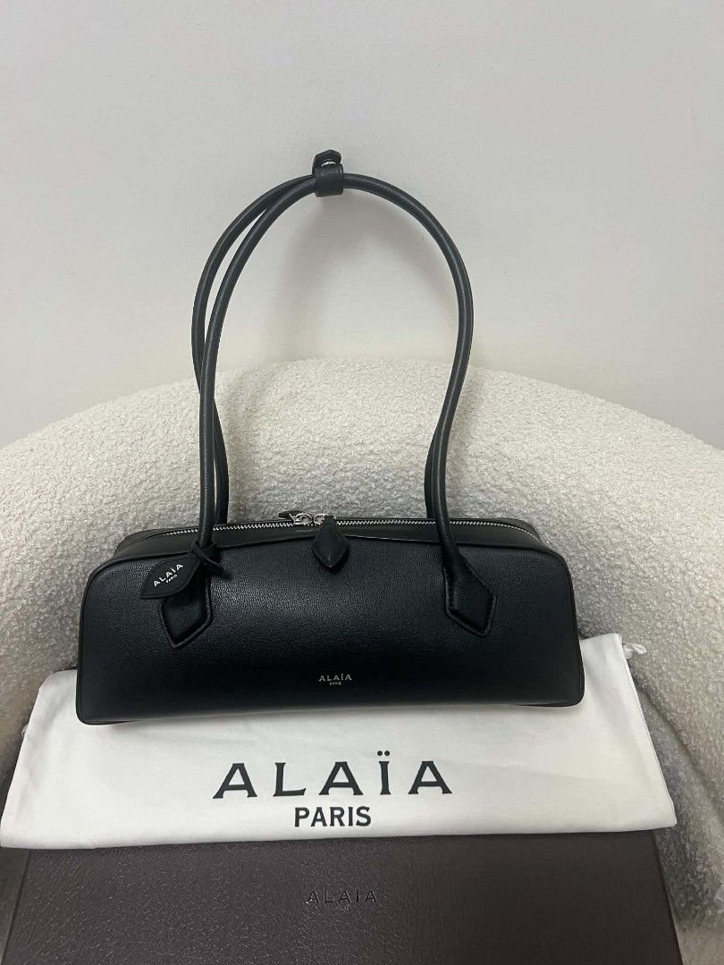Alaïa East West Leather Shoulder Bag (Category: Shoulder Bags) located in Paoay. Submitted by rvf1230 (Listing ID 1470818323, Image 1). Description: - Brand: Alaïa - Material: Premium black leather - Style: Sleek horizontal shoulder bag with dual top handles - Hardware: Silver-tone with secure zip closure and double pullers - Condition: Pristine, clean exterior - Inclusions: Original box and dust bag included.