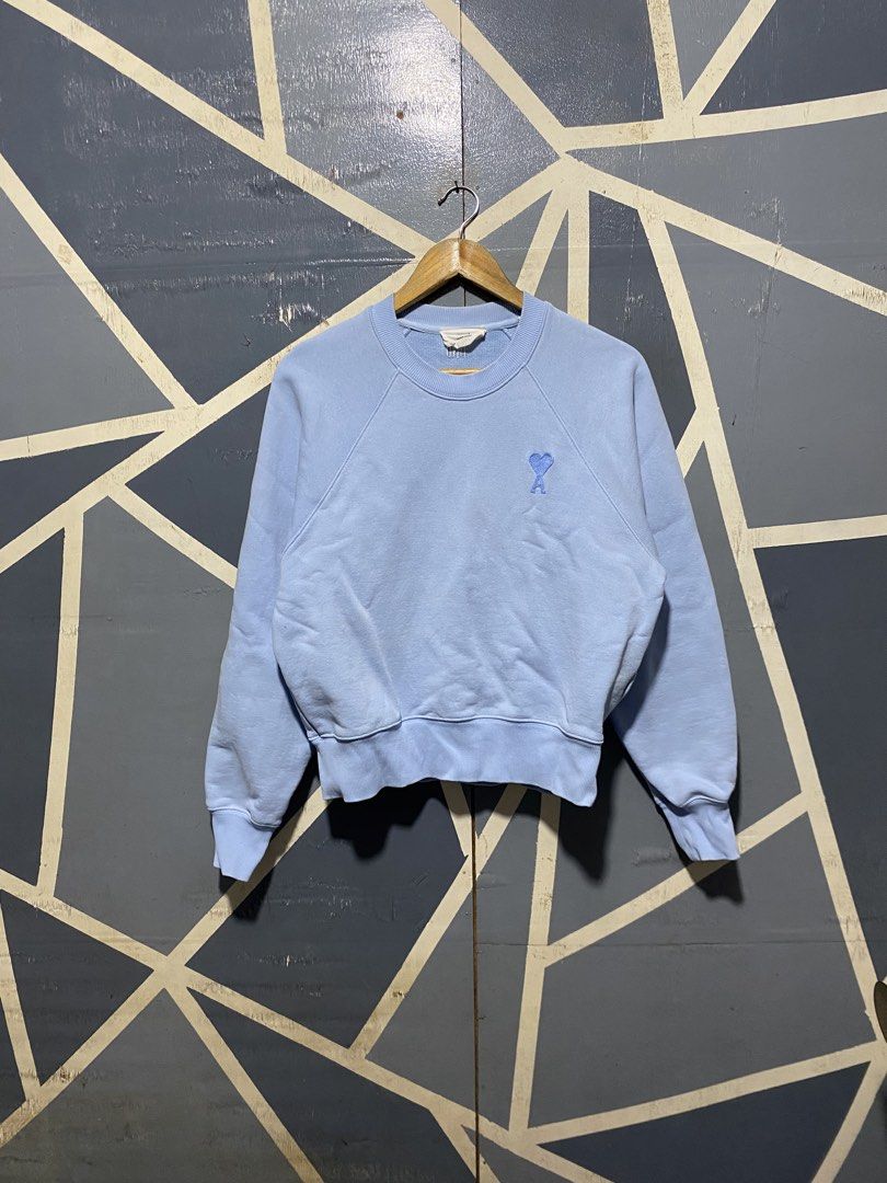 Ami Alexandre Mattiussi Light Blue Sweatshirt (Category: Others Tops) located in Polomolok. Submitted by marrssz (Listing ID 1470744217, Image 1). Description: - Brand: AMI Alexandre Mattiussi - Color: Light Blue - Material: Soft cotton fleece - Design: Crewneck with raglan sleeves - Details: Embroidered blue heart logo on chest and matching AMI lettering at back neckline - Finish: Ribbed collar, cuffs, and hem - Style: Clean look, perfect for ca
