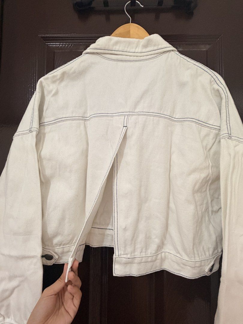 Andersson Bell White Denim Crop Jacket (Category: Coats, Jackets and Outerwear) located in Marikina City. Submitted by _bananahanaa (Listing ID 1470802472, Image 3). Description: - Brand: Andersson Bell - Color: White with contrast blue stitching and bright blue inner lining - Fit: Trendy cropped cut - Details: Oversized chest pockets, front button closure, and a unique split detail at the back - Condition: Good, with minor yellowing around the i