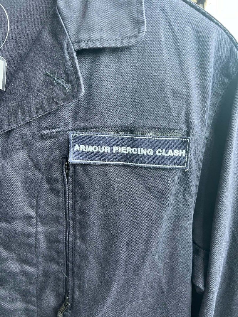 A.P.C. Rue De Fleurus Paris Armour Piercing Clash Jacket (Category: Coats, Jackets and Outerwear) located in Urdaneta. Submitted by jayceegarage (Listing ID 1470882261, Image 2). Description: - Brand: A.P.C. Rue De Fleurus Paris - Color: Dark blue - Size: Tagged Size 1 - Design: Unique 'Armour Piercing Clash' patch sewn on the chest - Pockets: Two vertical zipped chest pockets and two front flap pockets - Closure: Classic button front with collar
