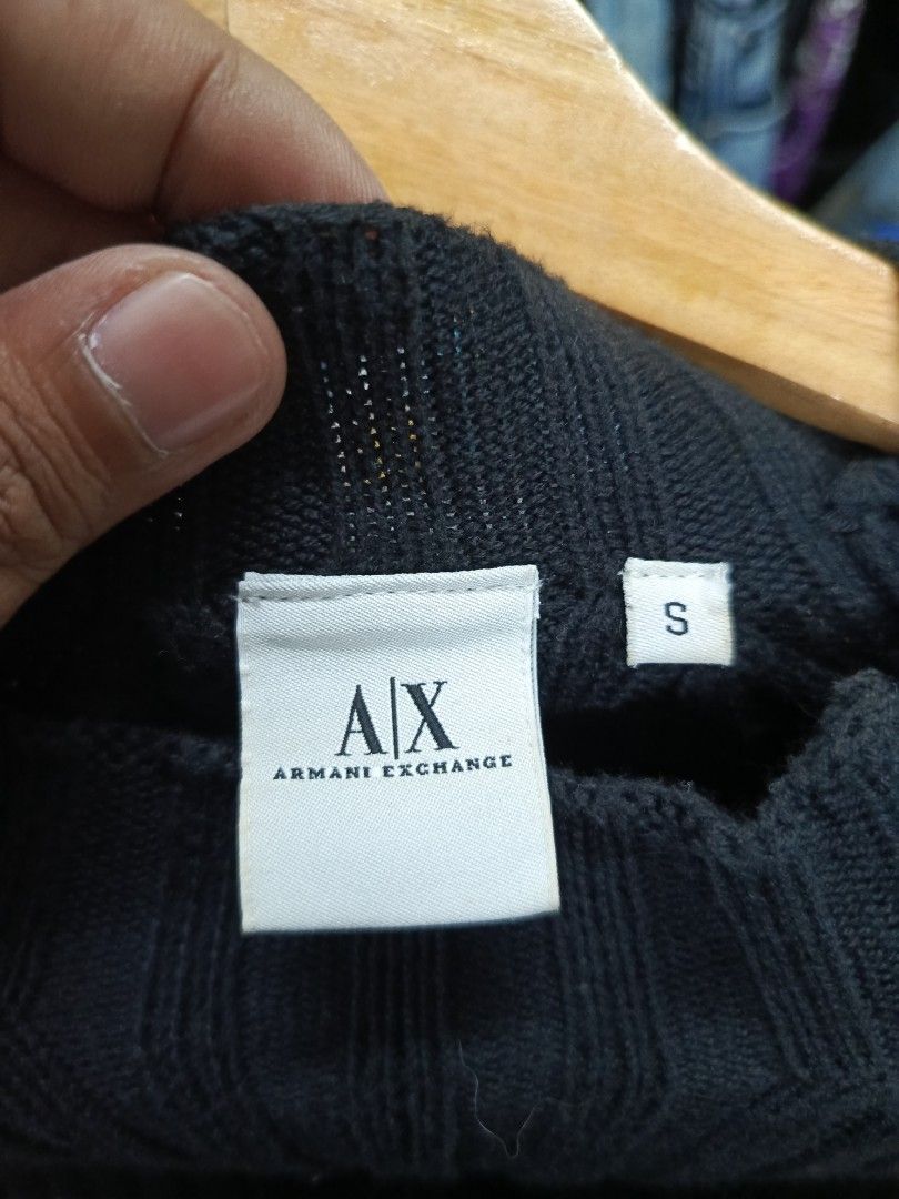 Armani Exchange Ribbed Knit Sweater Black Size S (Category: Longsleeves) located in Cabatuan. Submitted by penthegreat (Listing ID 1470826318, Image 2). Description: Black ribbed knit sweater from Armani Exchange. Long sleeves, high collar neckline. Zipper detail running down the shoulder with the brand name printed along it. Soft cotton blend material. Size small tag attached inside. Made in Hong Kong. Care label specifies machine wash cold inst