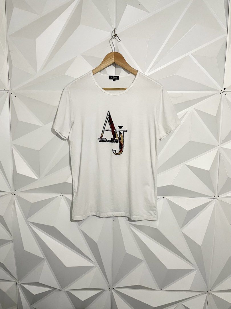 Armani Jeans White T-Shirt (Category: Tshirts & Polo Shirts ) located in Cabuyao City. Submitted by ParadisethriftedPh (Listing ID 1470924571, Image 1). Description: Cr: 9.2/10 Dimensions W: 19 L: 26 - Brand: Armani Jeans - Color: White - Size: L - Design: Large AJ logo graphic on the chest - Fit/Style: Classic crew neck, short sleeves - Condition: Clean fabric, great staple piece for casual wear.