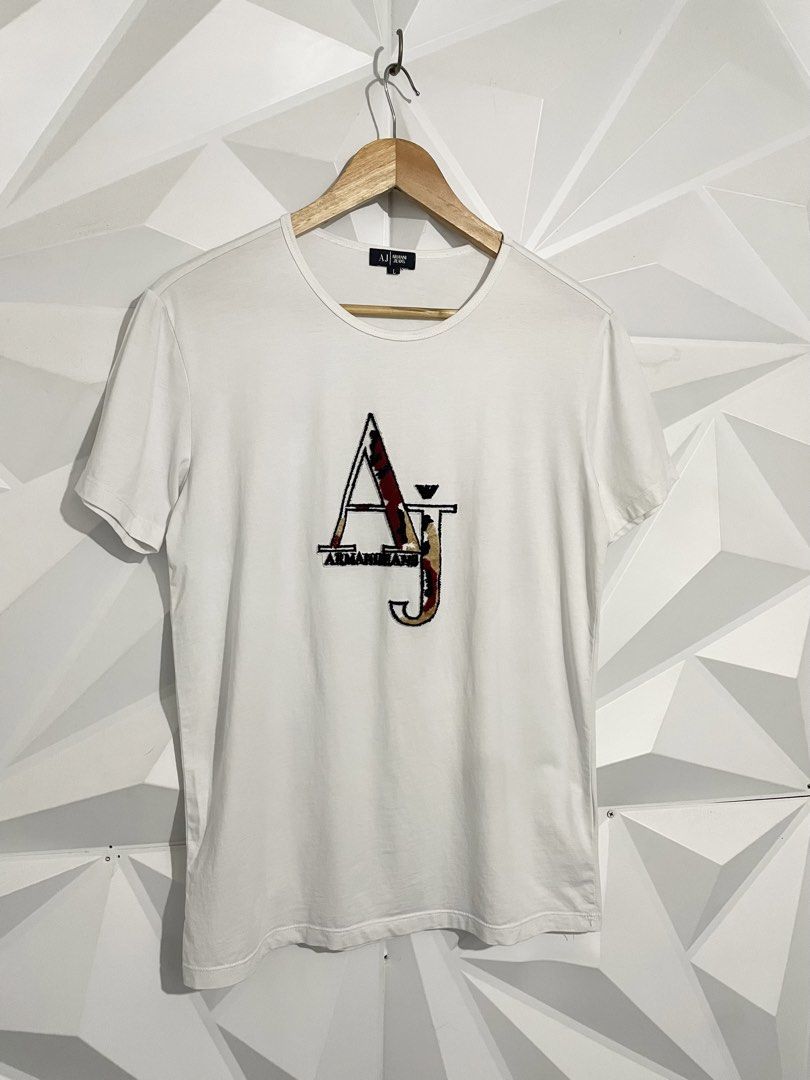 Armani Jeans White T-Shirt (Category: Tshirts & Polo Shirts ) located in Cabuyao City. Submitted by ParadisethriftedPh (Listing ID 1470924571, Image 2). Description: Cr: 9.2/10 Dimensions W: 19 L: 26 - Brand: Armani Jeans - Color: White - Size: L - Design: Large AJ logo graphic on the chest - Fit/Style: Classic crew neck, short sleeves - Condition: Clean fabric, great staple piece for casual wear.