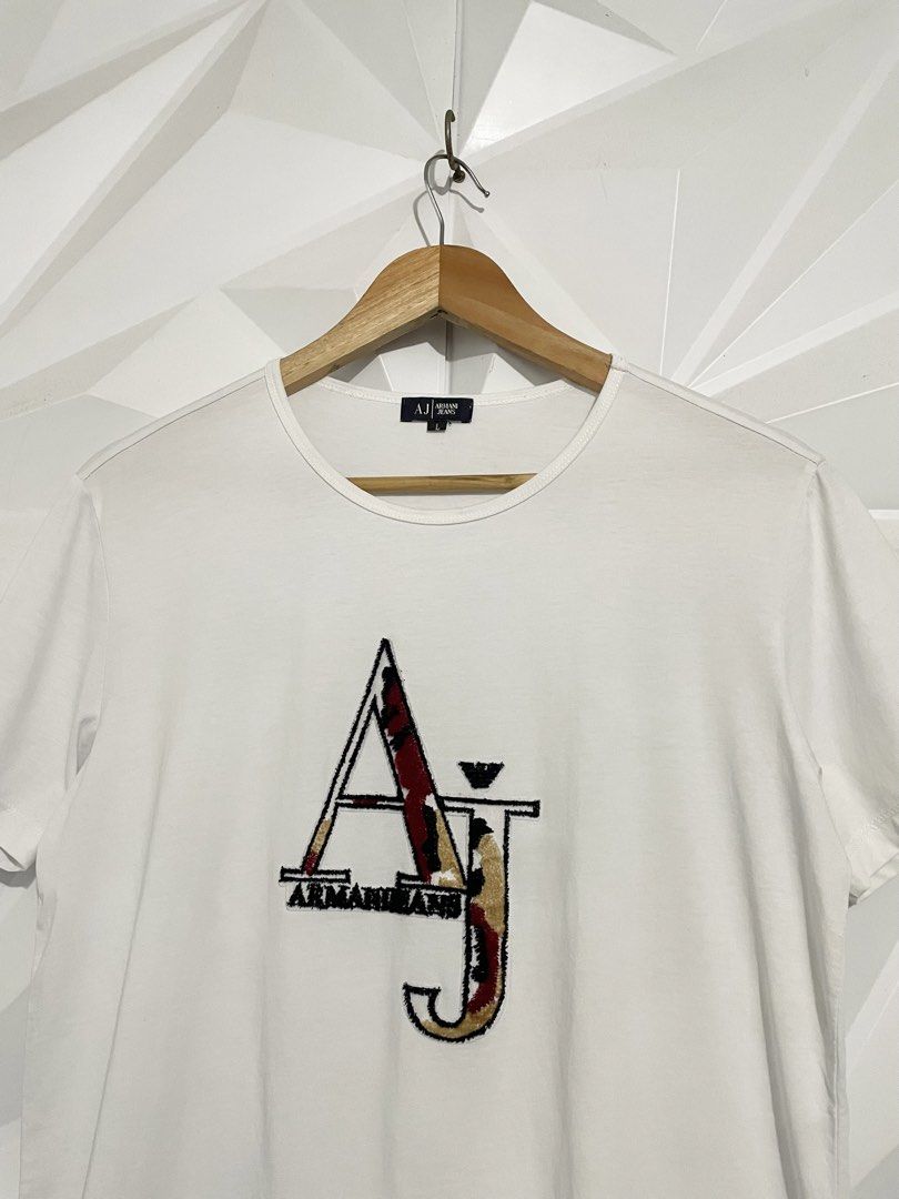 Armani Jeans White T-Shirt (Category: Tshirts & Polo Shirts ) located in Cabuyao City. Submitted by ParadisethriftedPh (Listing ID 1470924571, Image 3). Description: Cr: 9.2/10 Dimensions W: 19 L: 26 - Brand: Armani Jeans - Color: White - Size: L - Design: Large AJ logo graphic on the chest - Fit/Style: Classic crew neck, short sleeves - Condition: Clean fabric, great staple piece for casual wear.