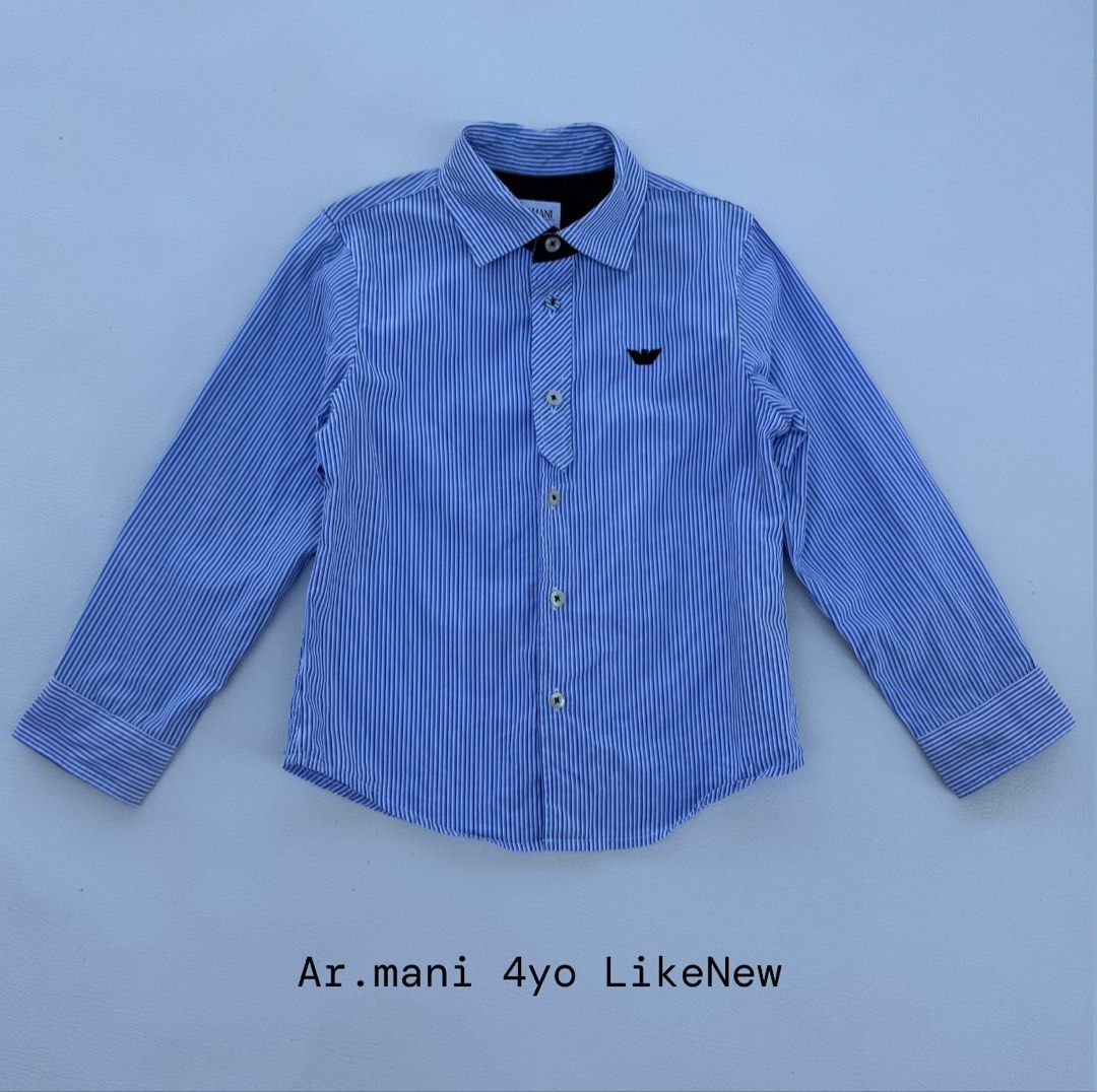 Armani Junior Blue Striped Button-Down Shirt 4yo (Category: Babies & Kids Fashion) located in Pozorrubio. Submitted by izaykite2g (Listing ID 1470769971, Image 1). Description: - Brand: Armani - Size: Suitable for 4 years old - Design: Classic blue & white vertical stripes with black inner collar trim - Details: Long sleeves, standard collar, front button closure, and signature eagle logo embroidery on chest - Condition: Clean, crisp, and well-ma