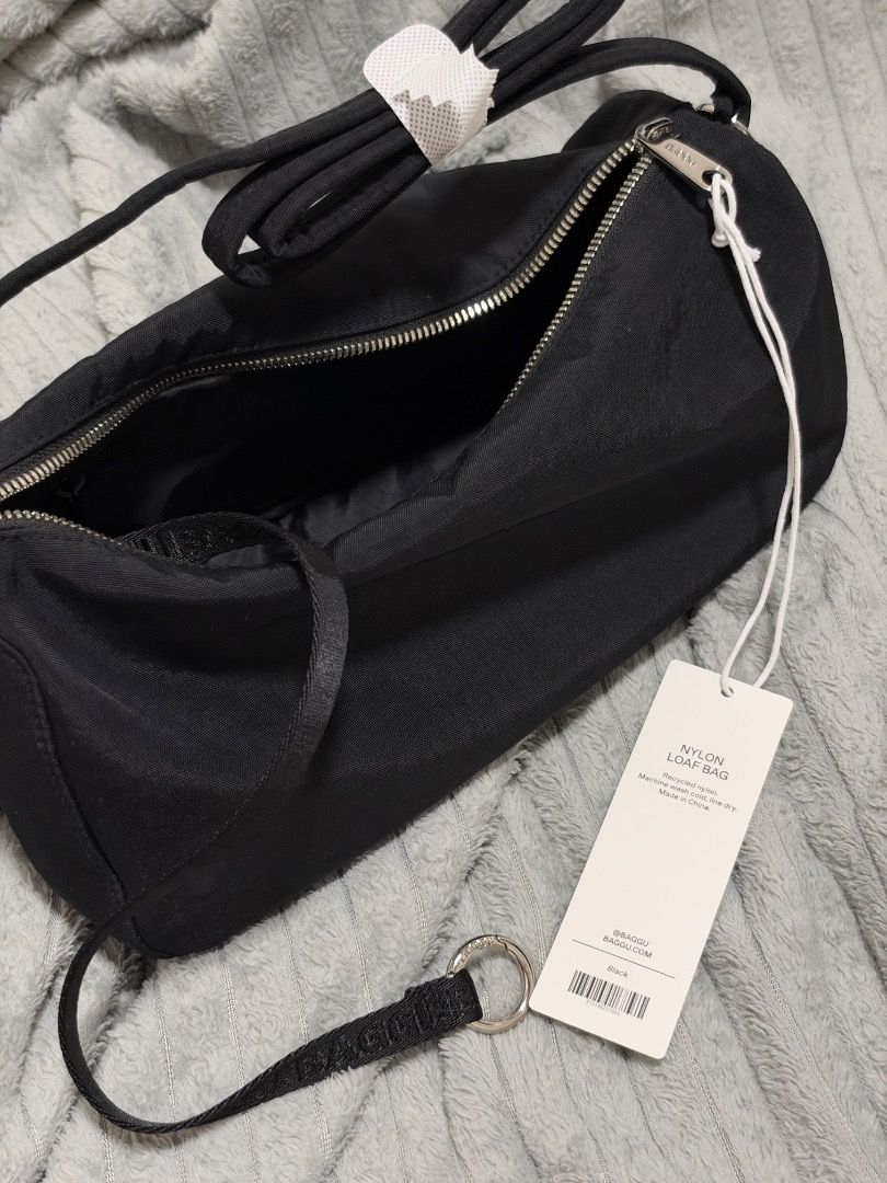 Baggu Nylon Loaf Bag Black (Category: Tote Bags) located in Quezon City. Submitted by kkkbm013 (Listing ID 1470827747, Image 3). Description: - Brand: Baggu - Style: Nylon Loaf Bag - Color: Classic Black - Condition: Brand new, never used, straight out of packaging with original hangtag attached - Features: Secure top zipper closure, adjustable strap with plastic protection - Bonus: Cute smiley face zipper pull charm (still wrapped in plastic) FR