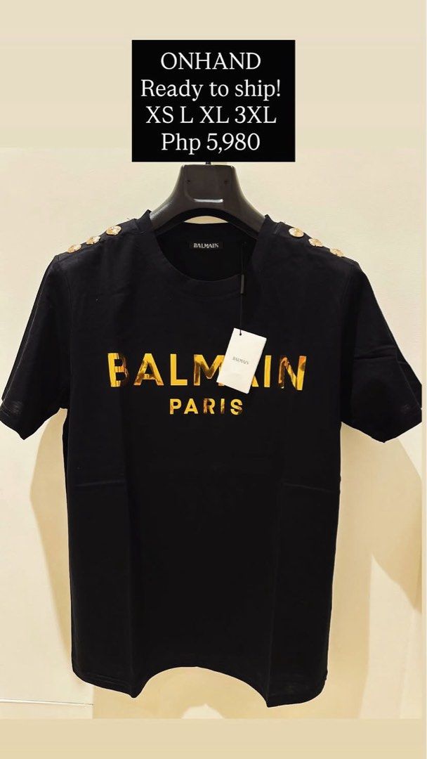 Balmain classic 3 button size XS (Category: Luxury Apparel) located in Muntinlupa City. Submitted by bagaholicmom (Listing ID 1470790434, Image 1). Description: - Brand: Balmain Paris - Color: Black with metallic gold foil logo - Style: Classic crewneck, short sleeves, decorative gold-tone shoulder buttons - Condition: Brand new with original tags attached.