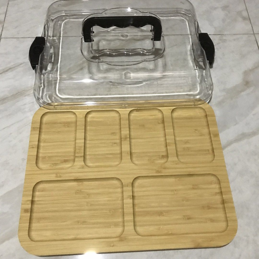 Bamboo Serving Tray with Clear Plastic Lid and Handle (Category: Food Organization & Storage) located in Manila. Submitted by magimi (Listing ID 1470849081, Image 2). Description: - Material: Eco-friendly bamboo wooden tray - Compartments: 6 divided sections for organizing various snacks or appetizers - Lid: Clear plastic cover with secure black locking clips on both sides - Portability: Built-in top handle on the lid for easy carrying - Inclusio