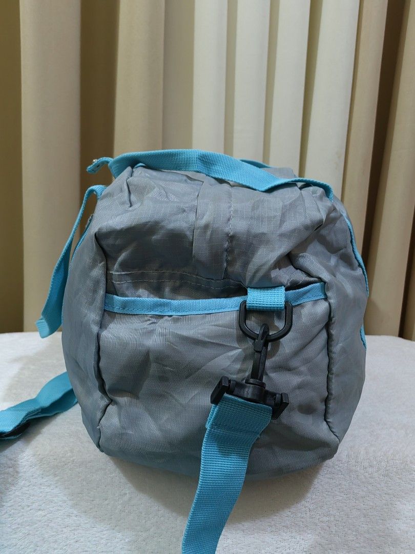 Bana Bana Grey and Blue Duffle Bag (Category: Sling Bags) located in Makati City. Submitted by prelovedtreatedwithlove (Listing ID 1470879102, Image 3). Description: - Color: Grey with bright blue handles - Material: Lightweight nylon - Size: Medium (ideal for gym sessions and short trips) - Features: Front pocket with Bana Bana logo patch, side hooks for the strap - packable. Unisex No issue. Excellent condition ready to ship.