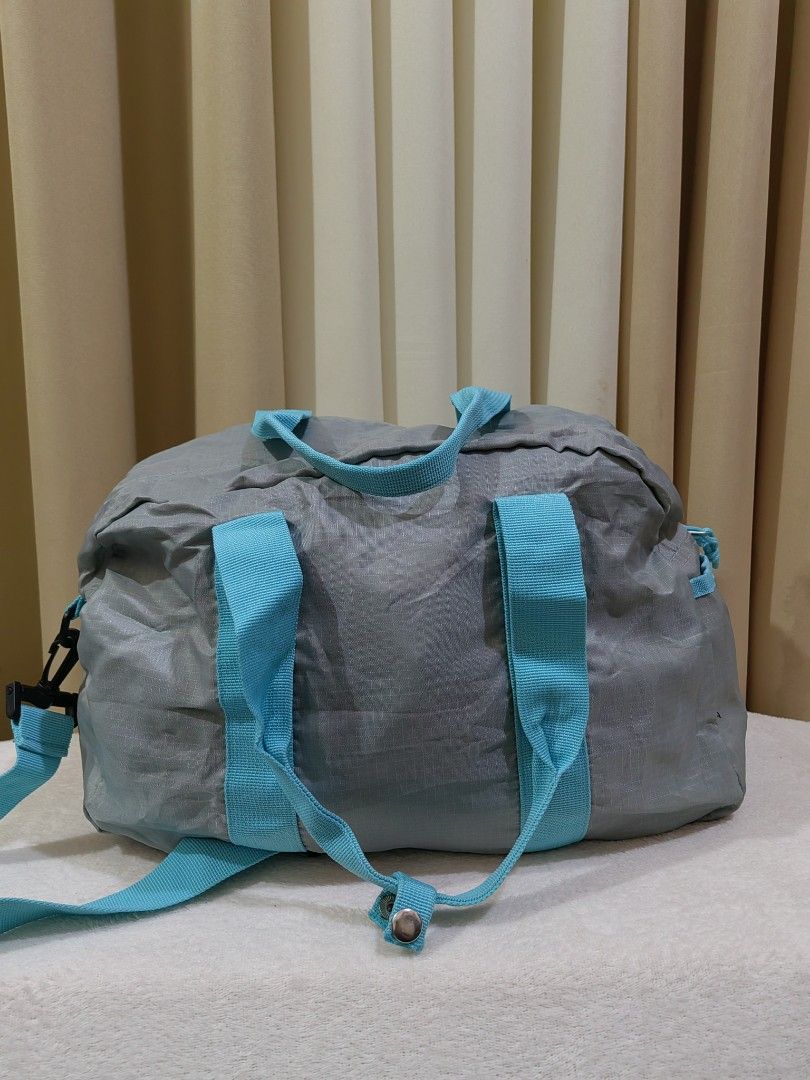 Bana Bana Grey and Blue Duffle Bag (Category: Sling Bags) located in Makati City. Submitted by prelovedtreatedwithlove (Listing ID 1470879102, Image 2). Description: - Color: Grey with bright blue handles - Material: Lightweight nylon - Size: Medium (ideal for gym sessions and short trips) - Features: Front pocket with Bana Bana logo patch, side hooks for the strap - packable. Unisex No issue. Excellent condition ready to ship.