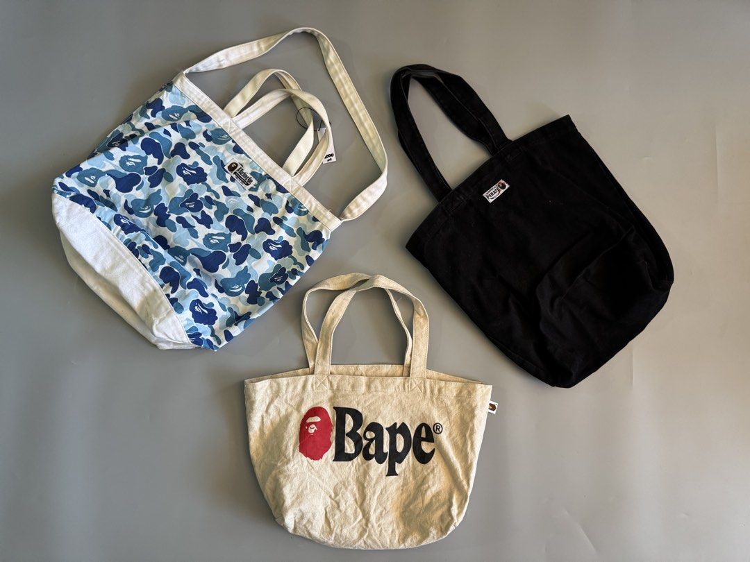 BAPE Tote Bag Bundle Set of 3 (Category: Tote Bags) located in Baguio. Submitted by stockedclothing047 (Listing ID 1470756790, Image 2). Description: BATHING APE CANVASS TOTE BAGS BALE BLUE CAMO 2180 (NEEDS CLEANING) BAPE PIRATE BLACK 1580 BAPE WHITE SPELLOUT 1380 4.5k AS PACK (PRIO) - 3-Piece BAPE Tote Bag Bundle - Blue camo shoulder bag with white base - Black canvas tote featuring iconic ape head and crossbones graphic - Cream-colored tote wit