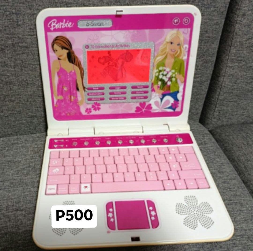 Barbie B-Smart Educational Toy Laptop (Category: Kids Toys) located in Quezon City. Submitted by robelles_thriftshop (Listing ID 1470930509, Image 1). Description: - Official Barbie B-Smart kids educational laptop (Item E-8098-080) - Features interactive games, typing practice, math, and Spanish lessons - Stylish pink keyboard and functional touchpad layout - Combines fun entertainment with early learning - Requires 3x AA batteries (batteries not