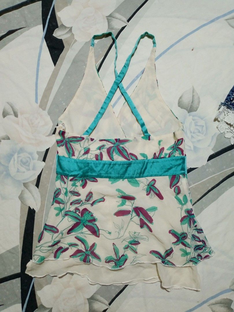 bebe Floral Halter Tank Top Size S (Category: Sleeveless) located in Dumaguete. Submitted by morie_luna15 (Listing ID 1470839676, Image 3). Description: - Brand: Bebe - Style: Y2K halter tank top with a layered hem - Color/Print: Cream with green and purple floral print - Details: Teal satin band under the bust - Size: S (tag on collar) - Material: Lightweight fabric - Origin: Made in China - Condition: Great pre-loved piece.