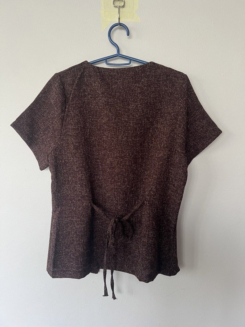 BETTY Brown Short Sleeve Button Top with Tie Back (Category: Blouses) located in San Fernando. Submitted by wearvfs (Listing ID 1470887584, Image 2). Description: - Brand: BETTY - Color: Brown textured - Neckline: V-neck with 3 gold-tone decorative buttons - Fit: Self-tie ribbon at the back waist for a cinched look - Sleeves: Short sleeves - Material: Lightweight and comfortable - Size/Measurement: Pit to pit approx. 44 cm - Condition: Great, wel