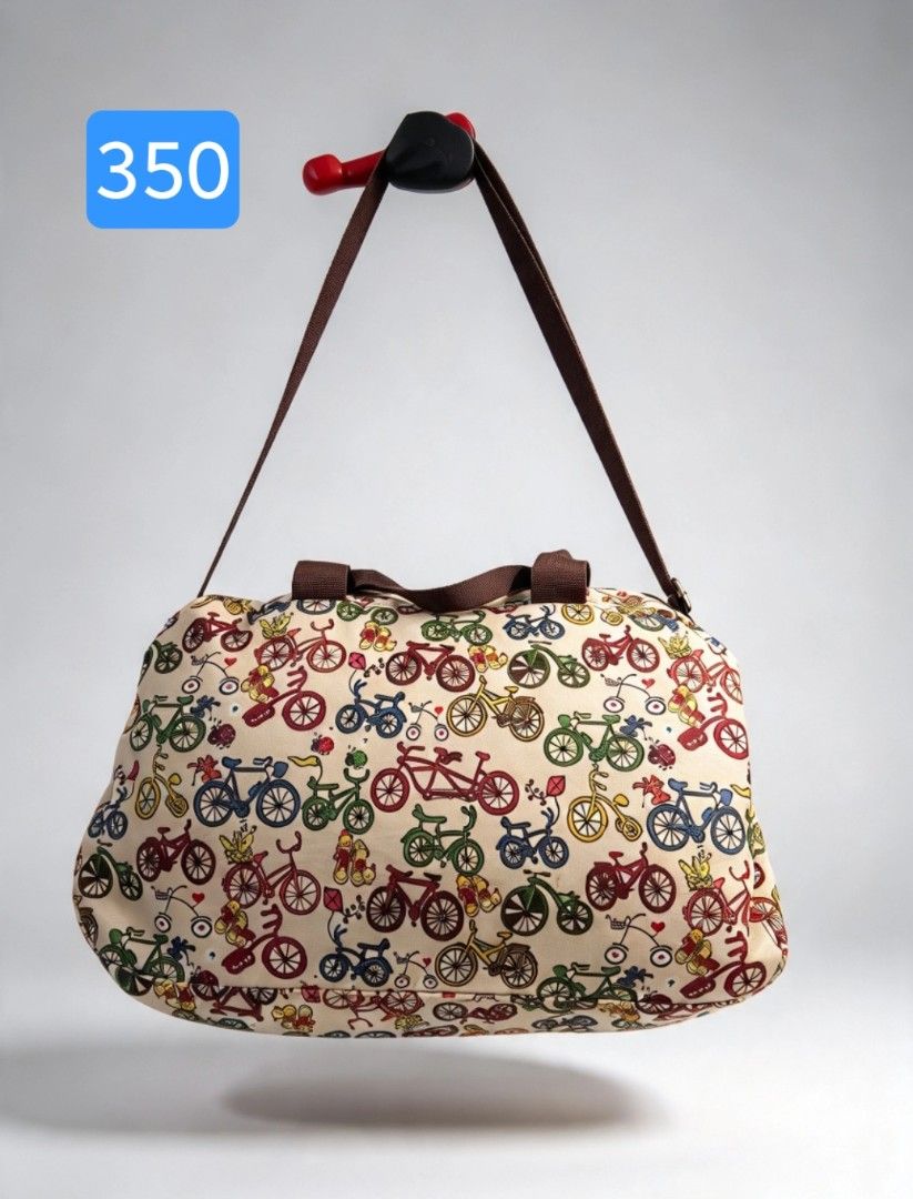 Bicycle Pattern Travel Duffel Bag with Shoulder Strap (Category: Shoulder Bags) located in Angeles City. Submitted by anneps (Listing ID 1470856257, Image 1). Description: - Design: Cream duffel with a vibrant, colorful bicycle print and brown carrying handles - Versatile Carry: Includes an adjustable and detachable shoulder strap for convenience - Interior: Roomy black fabric lining featuring a secure zipped side pocket - Size: Measures roughly 