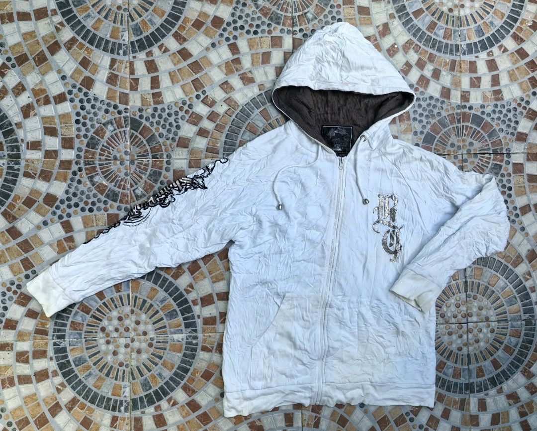 Big Train White Zip Up Hoodie Size M (Category: Coats, Jackets and Outerwear) located in Quezon. Submitted by miksxthrift (Listing ID 1470786650, Image 1). Description: - Brand: Big Train - Color: White with brown waffle-knit hood lining - Size: M (tag attached) - Design: Large graphic print on the back and metallic logo on the chest - Features: Front pockets, ribbed cuffs and hem, drawstrings with metal aglets - Condition: Excellent/Ready to wea