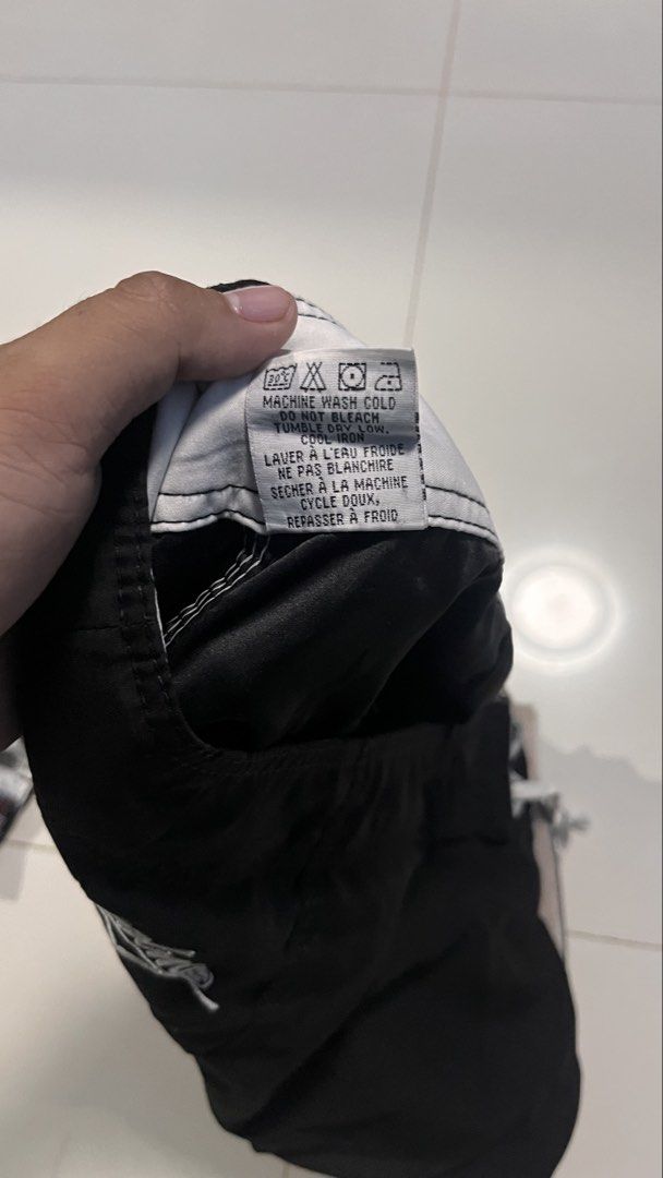 Billabong Black Board Shorts Size 32 (Category: Swim Trunks & Board Shorts) located in Manila. Submitted by wildfire-06ed46 (Listing ID 1470879199, Image 3). Description: - Brand: Billabong - Color: Solid Black - Size: 32 - Material: 100% Polyester - Closure: Drawstring waist - Pockets: Side cargo pocket with buttonhole drain holes - Details: Embroidered brand logos on leg and back waistband - Care: Machine washable.