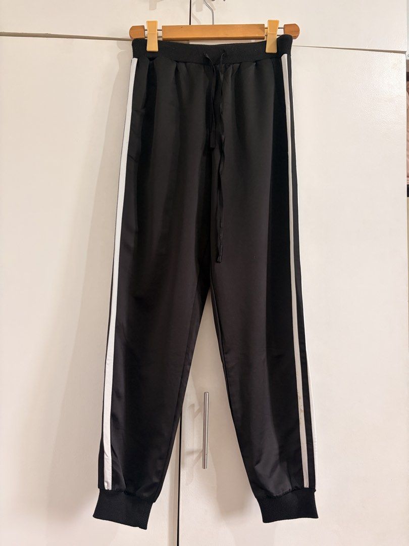Black and White Striped Track Pants (Category: Joggers) located in Marikina City. Submitted by _bananahanaa (Listing ID 1470797703, Image 1). Description: - Color: Black with white stripe on each side - Waistband: Elastic with adjustable drawstring tie - Ankle Cuffs: Ribbed for a secure fit - Material: Comfortable and easy to move in - Best for: Lounging or working out - Size small-medium.
