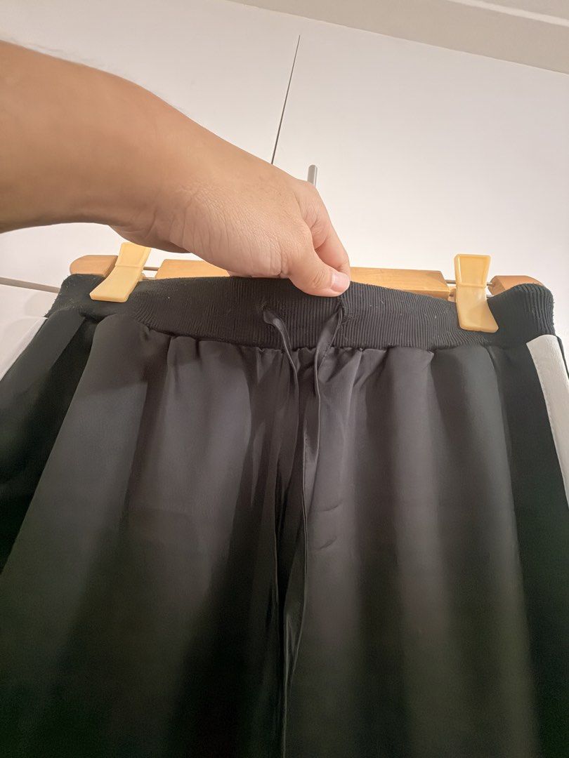 Black and White Striped Track Pants (Category: Joggers) located in Marikina City. Submitted by _bananahanaa (Listing ID 1470797703, Image 2). Description: - Color: Black with white stripe on each side - Waistband: Elastic with adjustable drawstring tie - Ankle Cuffs: Ribbed for a secure fit - Material: Comfortable and easy to move in - Best for: Lounging or working out - Size small-medium.