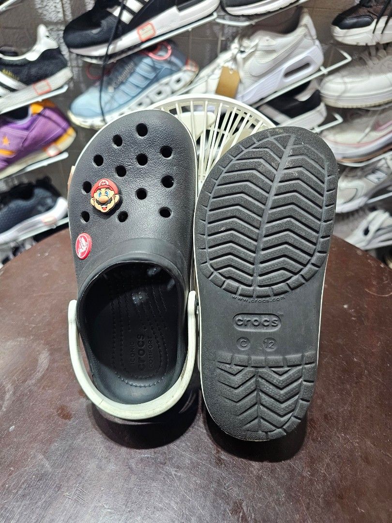 Black Crocs Crocband clogs FREE SHIPPING!!! (Category: Babies & Kids Fashion) located in Baguio. Submitted by kayeonlineshop (Listing ID 1470768178, Image 2). Description: • Model Style: This is the Crocs Crocband Clog, identifiable by the smooth upper texture and the distinct sporty white stripe wrap running along the midsole band. • Personalized Charms: The left shoe is decorated with a couple of custom Jibbitz™ shoe charms, including a promine