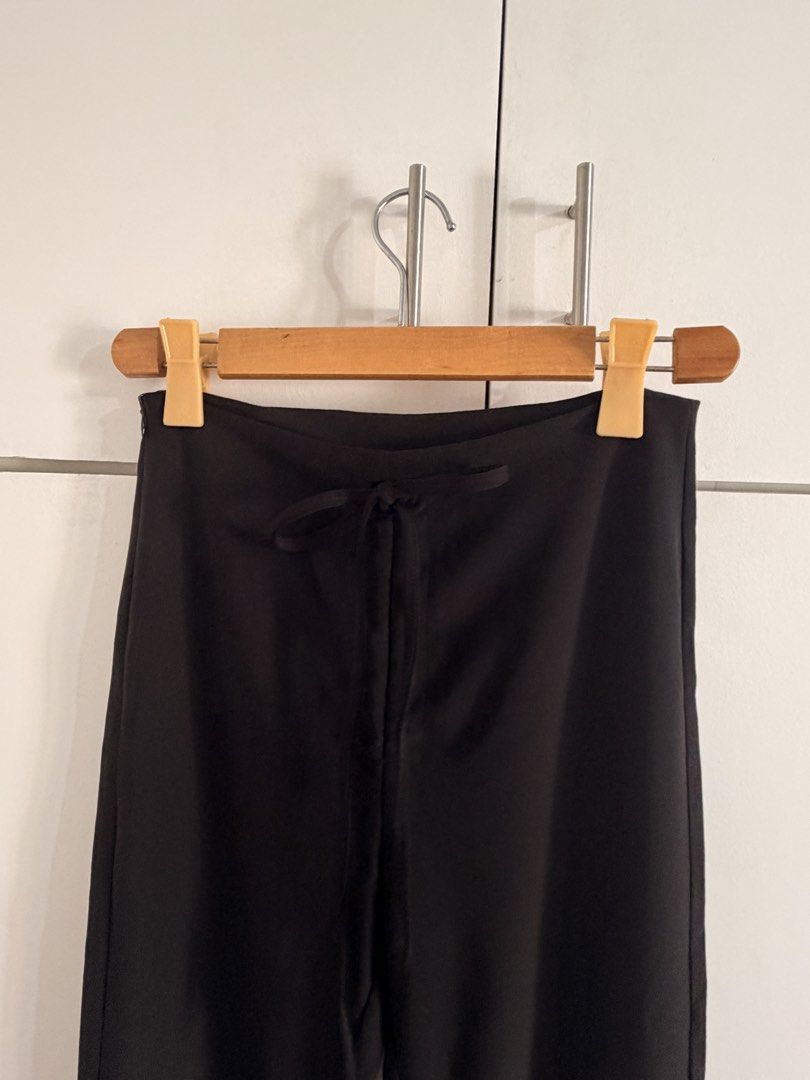 Black flare pants with side zip and drawstring waist (Category: Jeans) located in Marikina City. Submitted by _bananahanaa (Listing ID 1470801620, Image 3). Description: - Color: Solid black - Fit: High-waisted with flared legs from the knee down - Closure: Convenient side zipper - Detail: Subtle front drawstring - Fabric: Smooth and comfortable - Styling: Perfect for both casual and dressy occasions size 27-28.