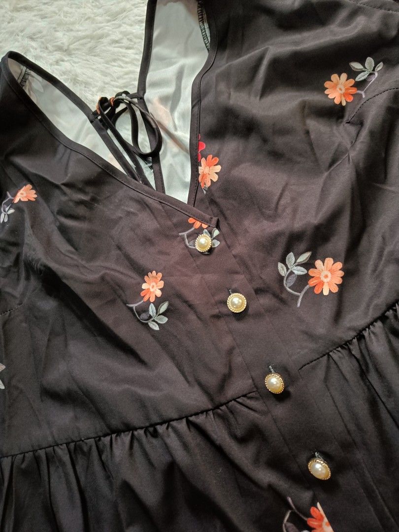Black floral top with pearl buttons (Category: Bikinis & Swimsuits) located in Orani. Submitted by mbfb_btn (Listing ID 1470824914, Image 2). Description: -Brandnew Style: Cute one-piece swimsuit - Color/Pattern: Black base with vibrant orange and red floral print all over - Neckline: Flattering V-neck with decorative pearl-accented buttons on the front - Straps: Adjustable straps that tie securely in the back - Condition: Brand new, perfect for 