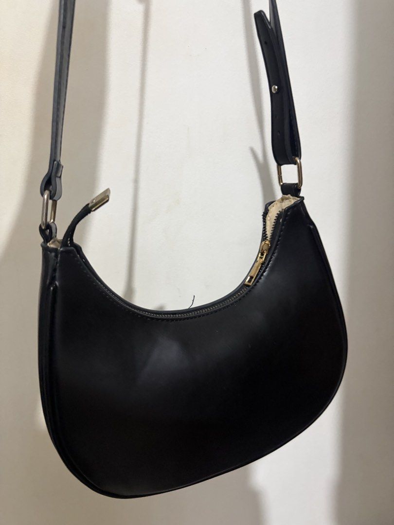 Black hobo shoulder bag with adjustable strap (Category: Shoulder Bags) located in Quezon City. Submitted by clareb (Listing ID 1470880344, Image 1). Description: - Color: Classic Black - Material: Smooth faux leather with light fabric lining - Design: Trendy curved crescent hobo shape with minimalist style - Hardware: Elegant gold-tone hardware and metal square strap rings - Features: Secure top zipper closure and convenient interior slip pocket