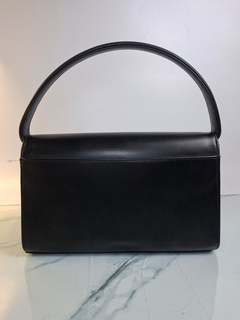 Black Leather Convertible Shoulder Bag With Gold Hardware (Category: Clutches) located in Pasay City. Submitted by onick_79 (Listing ID 1470918483, Image 2). Description: - Color: Sleek black -Dimensions: L25 x H16 x W7.5 cm - Material: Premium leather with structured rectangular shape - Closure: Front flap with a statement circular gold clasp - Straps: Includes a short leather shoulder strap and an interchangeable gold chain strap - Style: Versa