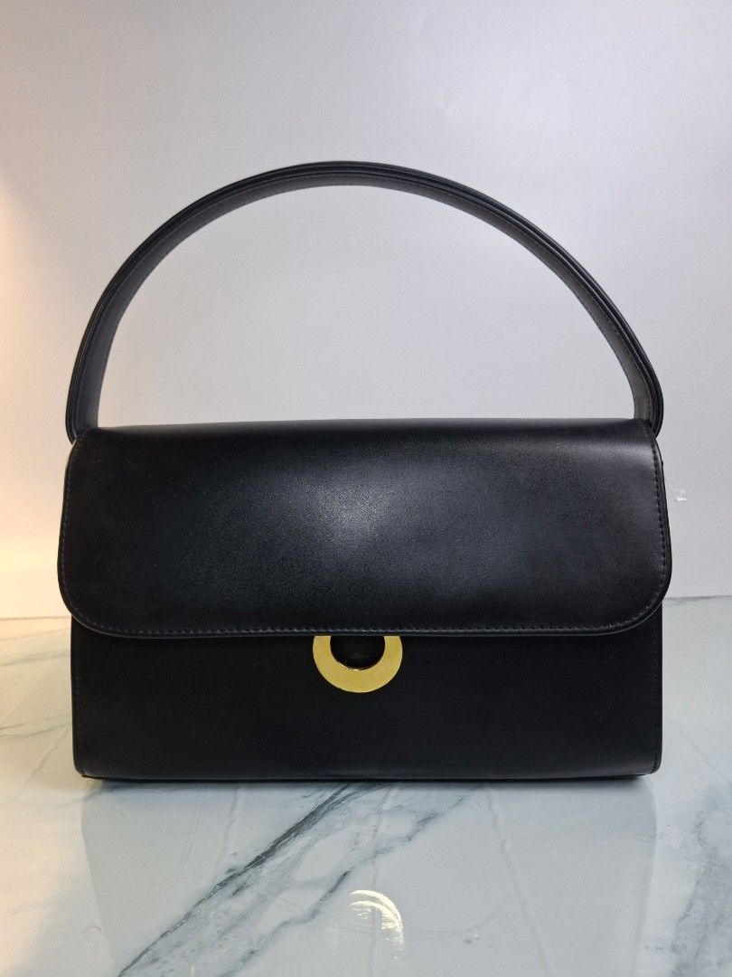 Black Leather Convertible Shoulder Bag With Gold Hardware (Category: Clutches) located in Pasay City. Submitted by onick_79 (Listing ID 1470918483, Image 1). Description: - Color: Sleek black -Dimensions: L25 x H16 x W7.5 cm - Material: Premium leather with structured rectangular shape - Closure: Front flap with a statement circular gold clasp - Straps: Includes a short leather shoulder strap and an interchangeable gold chain strap - Style: Versa