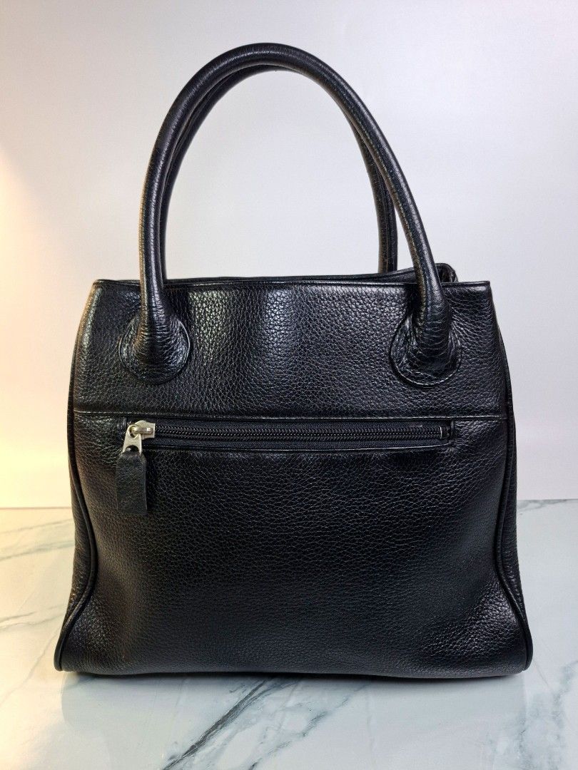Black Leather Handbag with Front Flap Pocket (Category: Tote Bags) located in Pasay City. Submitted by onick_79 (Listing ID 1470919369, Image 2). Description: - Material: Premium black pebble grain leather -Dimensions: L 30 x H 26 x W 10 cm - Design: Structured shape with solid hardware - Carry: Comfortable dual top handles - Storage: Front flap compartment with magnetic snap closure and back exterior zipper pocket - Interior: Clean and spacious 