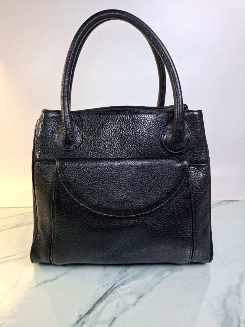 Black Leather Handbag with Front Flap Pocket (Category: Tote Bags) located in Pasay City. Submitted by onick_79 (Listing ID 1470919369, Image 1). Description: - Material: Premium black pebble grain leather -Dimensions: L 30 x H 26 x W 10 cm - Design: Structured shape with solid hardware - Carry: Comfortable dual top handles - Storage: Front flap compartment with magnetic snap closure and back exterior zipper pocket - Interior: Clean and spacious 