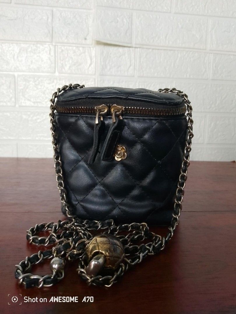 Black Quilted Vanity Crossbody Bag With Chain Strap (Category: Cross-body Bags) located in Manila. Submitted by littlelove25 (Listing ID 1470923607, Image 1). Description: - Style: Vanity crossbody bag - Material: Black faux leather with quilted diamond pattern - Closure: Zip top with dual pull tabs - Strap: Long chain strap woven with leather - Hardware: Gold tone (minor tarnishing on decorative ball charm) - Details: Small gold flower emblem on
