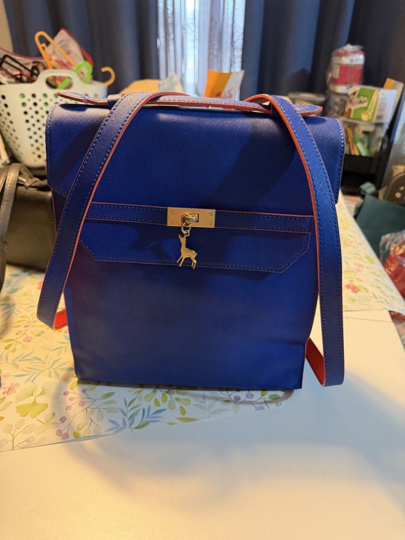 Blue and Red Backpack with Gold Deer Charm (Category: Backpacks) located in Manila. Submitted by fitandshop (Listing ID 1470873834, Image 2). Description: - Color: Bright blue with striking red edges and straps - Closure: Structured flap top with a secure gold-tone lock - Details: Adorable gold deer charm dangling from the front - Features: Convenient top handle on the back panel for easy grabbing - Style: Clean lines, ideal for everyday school o