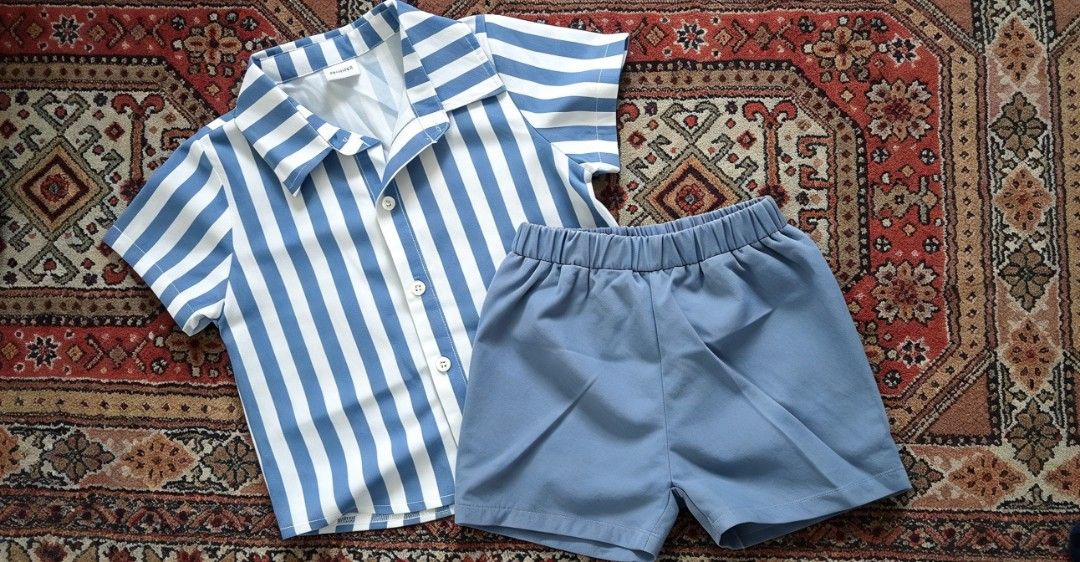 Blue and White Striped Shirt with Plain Shorts Set (Category: Babies & Kids Fashion) located in Manila. Submitted by charlottej01596 (Listing ID 1470748921, Image 1). Description: - Style: Matching two-piece kids outfit - Top: Short-sleeve button-down shirt with blue and white vertical stripes and camp collar - Bottoms: Solid light blue pull-on shorts with a comfortable elastic waistband - Material: Soft and lightweight fabric ideal for warm weat