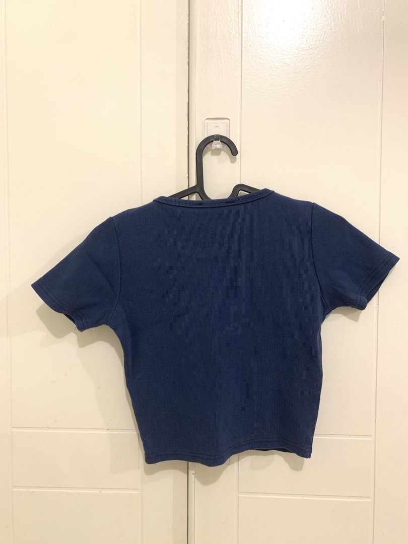 Blue Ribbed Crop Top Short Sleeve (Category: Shirts) located in Pasig City. Submitted by lovedbyri (Listing ID 1470873136, Image 3). Description: - Color: Dark blue - Style: Short sleeve crop top with scoop neckline - Fabric: Soft, stretchy textured ribbed material - Fit: Regular fit, sits right above the waist - Versatility: Great basic piece for high-waisted jeans or skirts - Condition/Details: Size tag attached inside.
