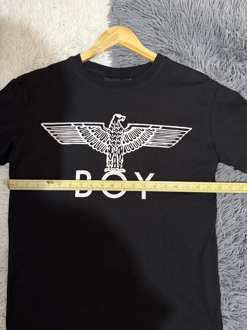 Boy London Eagle Logo Black T-Shirt (Category: Tshirts & Polo Shirts ) located in Manila. Submitted by keepercollection (Listing ID 1470831210, Image 3). Description: Boy London tee in classic black. Big white eagle graphic printed right on the front with bold BOY lettering underneath. Standard crew neck and short sleeves. Tag on the inside neck shows the brand. Clean fabric, measurements pictured with tape. Pit to pit measures around twenty inch