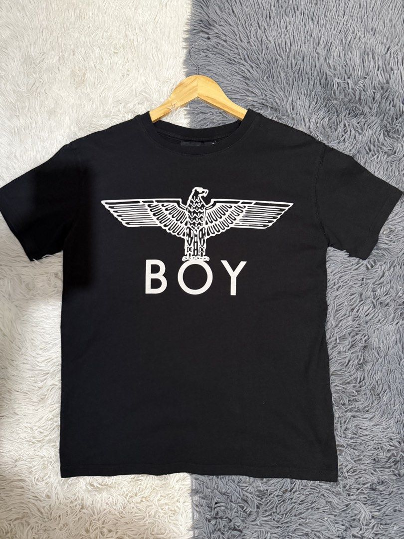 Boy London Eagle Logo Black T-Shirt (Category: Tshirts & Polo Shirts ) located in Manila. Submitted by keepercollection (Listing ID 1470831210, Image 1). Description: Boy London tee in classic black. Big white eagle graphic printed right on the front with bold BOY lettering underneath. Standard crew neck and short sleeves. Tag on the inside neck shows the brand. Clean fabric, measurements pictured with tape. Pit to pit measures around twenty inch