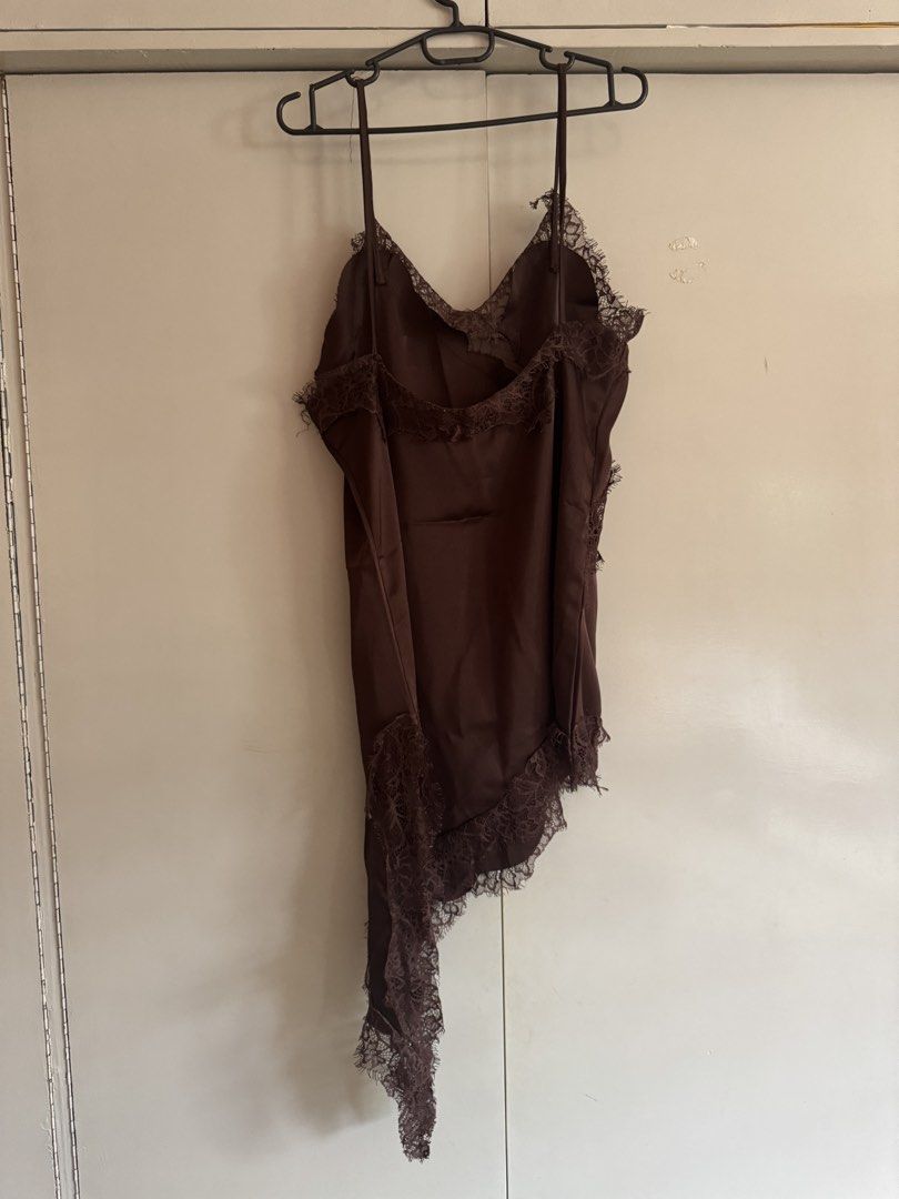 Brown asymmetrical lace cami top slip top (Category: Sleeveless) located in Taytay. Submitted by darkswan016 (Listing ID 1470829762, Image 2). Description: - Color: Dark brown - Material: Soft and silky satin fabric - Design: V-neck cut with delicate lace detailing on the front and back neckline - Straps: Thin spaghetti straps - Hemline: Asymmetrical hem with a chic, long draping side - Style: Perfect for layering or wearing on its own for a nigh